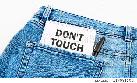 Do not Touch ME text written on a notebook on jeans on a white background 117081509