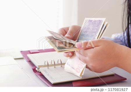 お金を数える女性の手元 お金を数える女性の手元 117081927