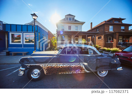 Vintage Car with Leopard Accents on Small Town Street, Lens Flare Effect 117082371