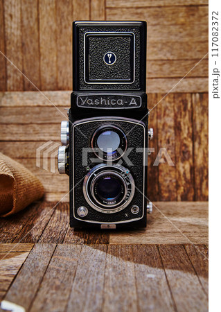 Vintage Yashica-A Twin-Lens Reflex Camera on Wooden Surface in Studio 117082372