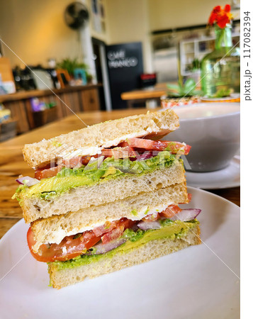 Fresh BLT Sandwich on White Plate in Cozy cafe, Eye-Level View 117082394