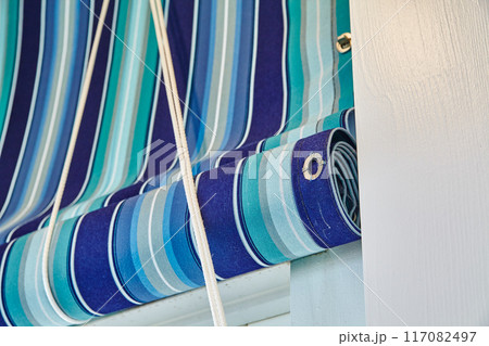 Blue Striped Retractable Curtains and White Rope Detail Blue Striped Retractable Curtains and White Rope Detail 117082497