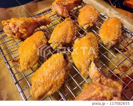 Crispy Fried Chicken Wings and Drumsticks on Cooling Rack 117082655