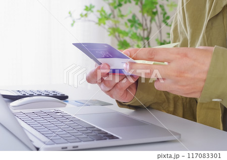 貯金通帳の内容を確認する男性 117083301