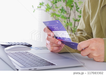 貯金通帳の内容を確認する男性 貯金通帳の内容を確認する男性 117083302