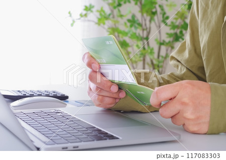 貯金通帳の内容を確認する男性 117083303