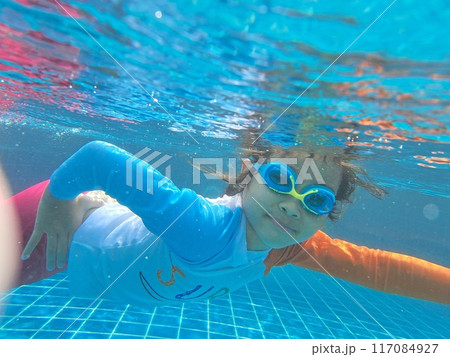Girl taking a photo of herself underwater happilyGirl taking a photo of herself underwater happily 117084927