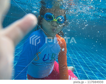Girl taking a photo of herself underwater happilyGirl taking a photo of herself underwater happily 117084930