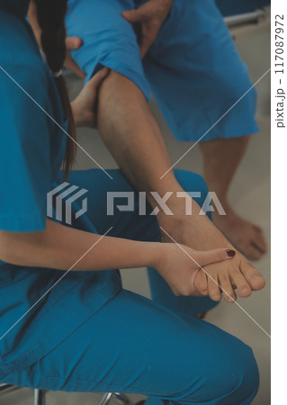 Physical therapists work with patients in close-up clinics. The concept of rehabilitation of physical health, the doctor gives advice to the patient. Ankle problems and muscle injuries 117087972