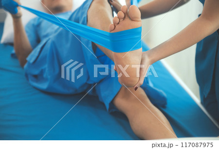 Physical therapists work with patients in close-up clinics. The concept of rehabilitation of physical health, the doctor gives advice to the patient. Ankle problems and muscle injuries 117087975