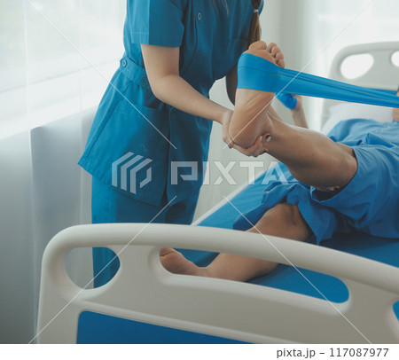 Physical therapists work with patients in close-up clinics. The concept of rehabilitation of physical health, the doctor gives advice to the patient. Ankle problems and muscle injuries Physical therapists work with patients in close-up clinics. The concept of rehabilitation of physical health, the doctor gives advice to the patient. Ankle problems and muscle injuries 117087977