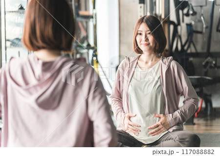 妊娠中にジムで運動・ストレッチ・マタニティトレーニングするプレママ・妊婦の女性 妊娠中にジムで運動・ストレッチ・マタニティトレーニングするプレママ・妊婦の女性 117088882