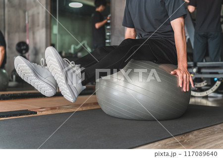 スポーツジムでバランスボールに乗る男性 スポーツジムでバランスボールに乗る男性 117089640