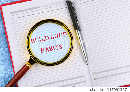 Healthy lifestyle and Healthy habits concept. Copy space. BUILD GOOD HABITS words through a magnifying glass in an open business notebook. Healthy lifestyle and Healthy habits concept. Copy space. BUILD GOOD HABITS words through a magnifying glass in an open business notebook. 117091337