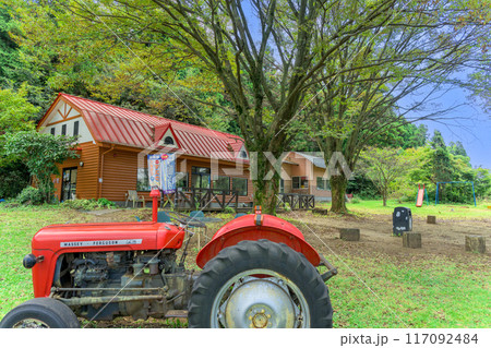 秋晴れを背景に売店の建物と牧場風景・トラクター風景「山田さんちの牧場 ミルクの里」阿蘇郡西原村 秋晴れを背景に売店の建物と牧場風景・トラクター風景「山田さんちの牧場 ミルクの里」阿蘇郡西原村 117092484