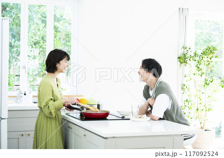 料理をしながら会話する夫婦 料理をしながら会話する夫婦 117092524