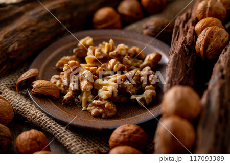 Walnut kernels and whole walnuts on a table. Walnut kernels and whole walnuts on a table. 117093389