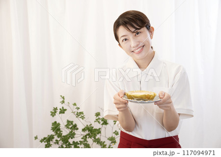 笑顔でケーキを運ぶカフェの女性スタッフ 笑顔でケーキを運ぶカフェの女性スタッフ 117094971