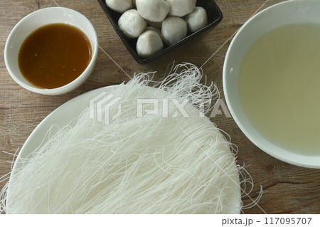 dry instant vermicelli thin noodles raw food on plate with steamed pork ball dipping spicy and sour chili sauce couple soup prepare to cook dry instant vermicelli thin noodles raw food on plate with steamed pork ball dipping spicy and sour chili sauce couple soup prepare to cook 117095707