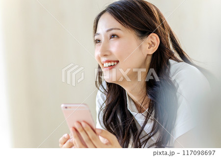 笑顔でスマホを見る女性 笑顔でスマホを見る女性 117098697