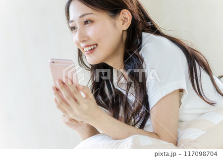 笑顔でスマホを見る女性 117098704