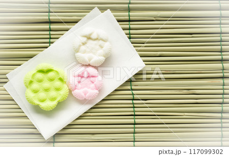 お盆で敷く真菰と盆菓子　御供菓子　和菓子　干菓子　落雁　まこも　お盆　ゴザ　背景素材 117099302