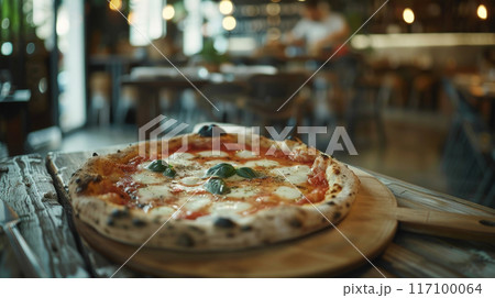Classic Neapolitan pizza on wooden table in authentic Italian restaurant background 117100064