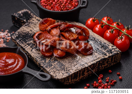 Fried sausages sliced with salt and spices as an ingredient for an English breakfast 117103051