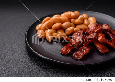 Fried sausages sliced with salt and spices as an ingredient for an English breakfast 117103060