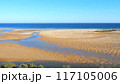Cacela Velha beach in Algarve, Portugal, Ria Formosa Natural Park. Vibrant blue ocean, expansive golden sands, and unique tidal formations. Ideal for summer beach vacations.  117105006