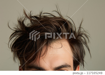 Close up detail of a modern shaggy men's hairstyle with messy, windswept strands, showcasing the trendy, unkempt look and individuality, perfect for a fashionable, casual, and carefree style 117105249