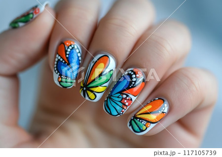 Close-up of a hand flaunting vibrant butterfly-inspired nail art with intricate wing patterns 117105739