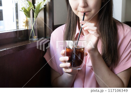 カフェでアイスコーヒーを飲む女性 117106349