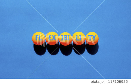 Flexibility symbol. Concept word Flexibility on beautiful yellow ping pong balls. Beautiful blue background. Business flexibility concept. Copy space. Flexibility symbol. Concept word Flexibility on beautiful yellow ping pong balls. Beautiful blue background. Business flexibility concept. Copy space. 117106926