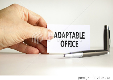 Adaptable office symbol. Concept words Adaptable office on beautiful white paper. Beautiful white background. Businessman hand. Business Adaptable office concept. Copy space. 117106958