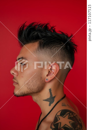 Side profile of a young adult showing off a modern faux hawk haircut with shaved sides against a red background 117107515