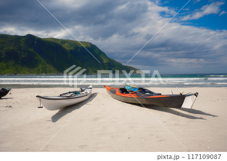 Kayaks on a sandy shore. Water sports. Active recreation and travel in summer time. Norway. Kayaks on a sandy shore. Water sports. Active recreation and travel in summer time. Norway. 117109087