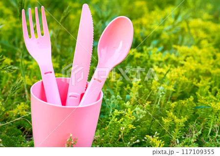 Camping sunset snack.Pink plastic dinnerware set.Cup,fork,knife,spoon 117109355