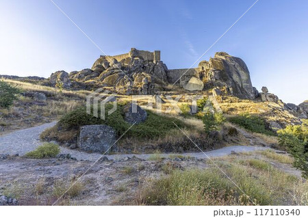 Panoramic image of the fortification above the historic town of Monsanto in Portugal during sunrise 117110340