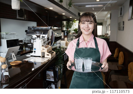 カフェで水を運ぶ女性スタッフ カフェで水を運ぶ女性スタッフ 117110573