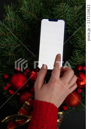 Christmas handmade wreath made of festive decorations with white screen phone copy space mock up template add website. Winter holiday celebration greeting card 117110621