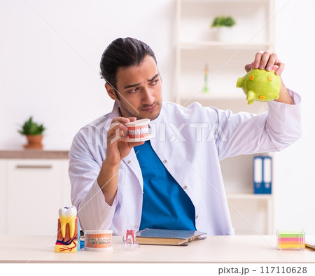 Young male dentist working in the clinic 117110628