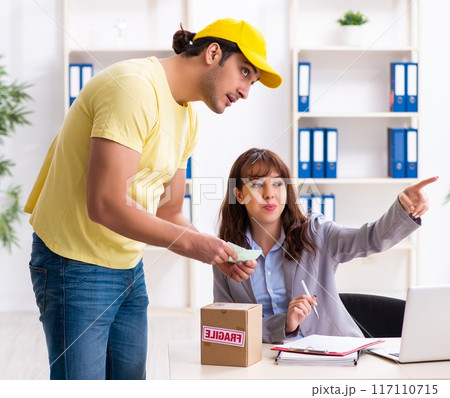 Young male courier delivering parcel to the office Young male courier delivering parcel to the office 117110715