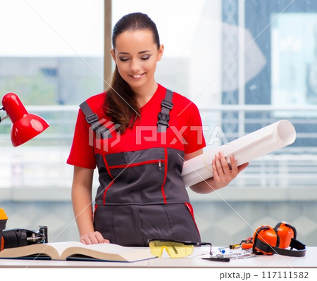Young woman in coveralls doing repairs 117111582