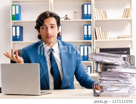 Young handsome busy employee sitting in office Young handsome busy employee sitting in office 117112350