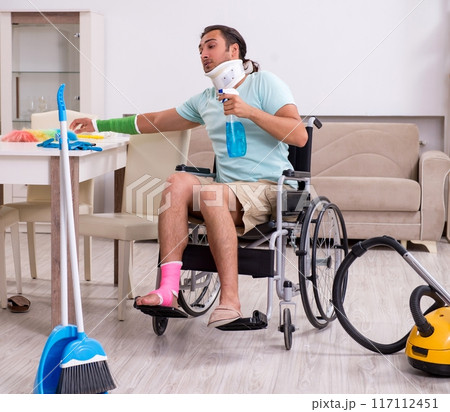 Young man in wheel-chair cleaning the house Young man in wheel-chair cleaning the house 117112451