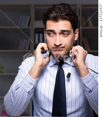 Tired and exhausted helpdesk operator during night shift 117112477