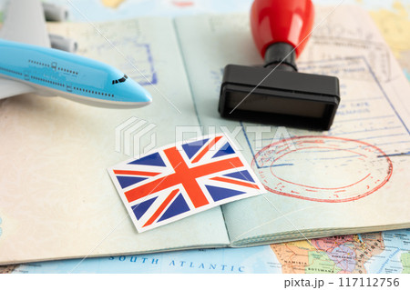 United Kingdom flag with approved Stamp visa and passport document to immigration at airport in country. 117112756