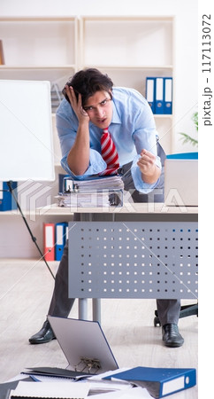 Young male employee unhappy with excessive work Young male employee unhappy with excessive work 117113072