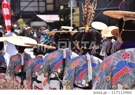 岐阜県高山市　春の高山祭　闘鶏楽と呼ばれる小さな鐘を鳴らす人達　鳥の絵が描かれた着物を着て笠を被る姿 117113460